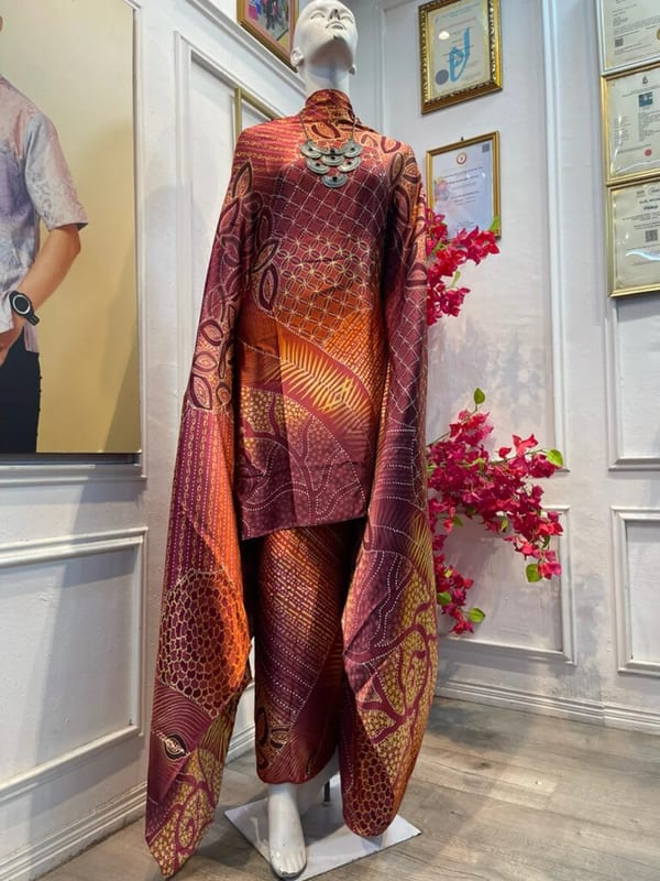 Satin silk batik fabric MD X1 in maroon and golden orange, draped on a mannequin